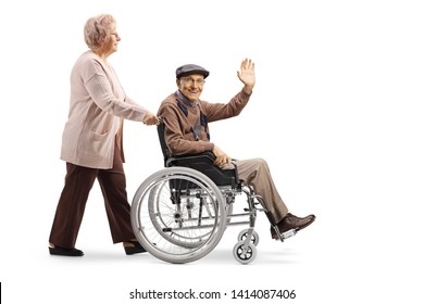 Full length shot of an elderly woman pushing an elderly man waving and sitting in a wheelchair isolated on white background - Powered by Shutterstock