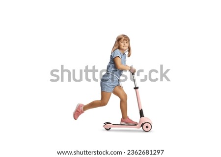 Full length shot of a girl riding a pink scooter and looking at camera isolated on white background