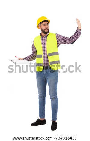Full length shot of handsome beard young engineer explaining something and holding a clipboard, guy wearing caro shirt and jeans with a yellow vest and yellow helmet, isolated on white background