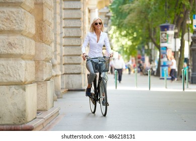 Full Length Shot Of A Happy Middle Aged Woman Riding A Bike In The City. 