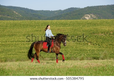Full length shot of happy young woman enjoy horseback riding at meadow. 