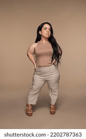 Full Length Shot Of Hispanic Woman In Her 20s With Dwarfism Posing On Neutral Background