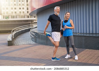 Full Length Shot Of Joyful Middle Aged Couple, Man And Woman In Sportswear Smiling Away, Standing Together Outdoors Ready For Workout