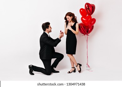 Full Length Shot Of Man Standing On Knee And Holding Wedding Ring. Romantic Boy Making Proposal To Girlfriend.