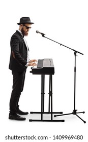 Full Length Shot Of A Man Standing, Playing A Digital Piano And Singing On A Microphone Isolated On White Background