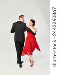 Full length shot of mature attractive couple in a tango dance pose isolated on grey background