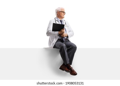 Full Length Shot Of A Mature Doctor Sitting On A Blank Panel And Looking To The Side Isolated On White Background