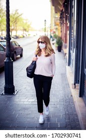 Full Length Shot Of Middle Aged Woman Walking On The Street And Wearing Respirator Mask For Health Protection While Rapidly Spreading Coronavirus Outbreak In The City.