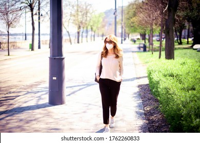 Full Length Shot Of Middle Aged Woman Walking On The Street And Wearing Face Mask For Health Protection While During Coronavirus Outbreak In The City.