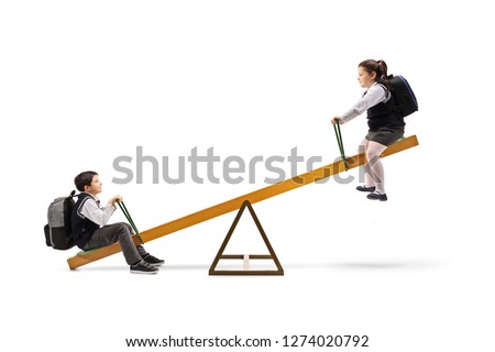 Full length shot of a schoolboy and a schoolgirl on a seesaw isolated on white background
