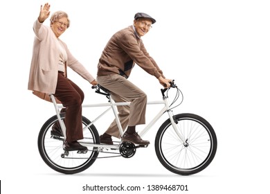 Full Length Shot Of A Senior Woman And Man Riding A Tandem Bycicle And Waving Isolated On White Background