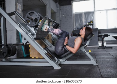 Full length shot of a sportswoman exercising at the gym on leg press machine, copy space - Powered by Shutterstock