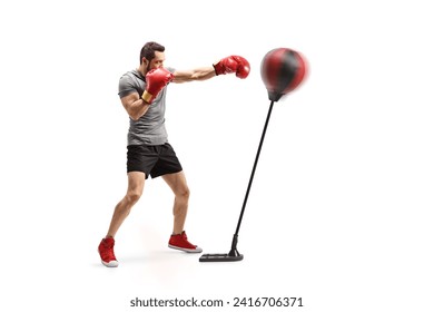 Full length shot of a strong young man punching a stand with boxing gloves isolated on white background - Powered by Shutterstock