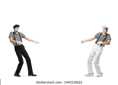Full length shot of two pantomime men pulling an imaginary rope isolated on white background