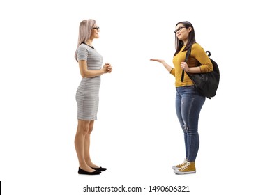 Full length shot of two young females having a conversation isolated on white background
