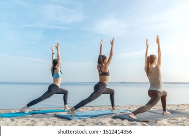 Full Length Shot Of Yoga Class At The Beach Outdoors