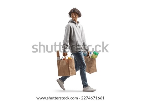 Full length shot of a young african american man carrying grocery bags walking and looking back isolated on white background