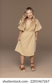 full length shot of young Caucasian woman in her teens who has down syndrome posing on a neutral background wearing a pretty dress Stock Photo