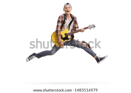 Full length shot of a young male musician playing an electric guitar and jumping isolated on white background
