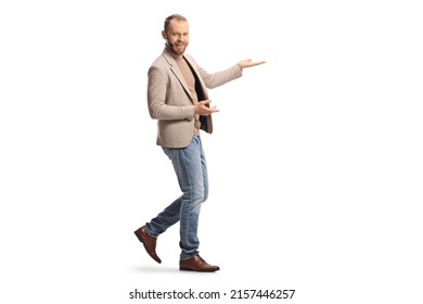 Full length shot of a young man with a headset showing something with hands isolated on white background - Shutterstock ID 2157446257