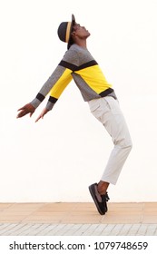 Full Length Side Portrait Of African Male Dancer Standing On His Tip Toes Making A Cool Dance Pose