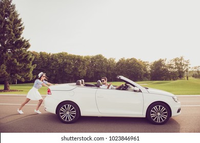 Full Length Side Profile Shot Of Gorgeous Brunette Lady In Cap And Brunet Guy Driver, Both Well Dressed, In Black Trendy Eyewear, Resolving The Car Problem, Park With Green Trees Around, Sunshine