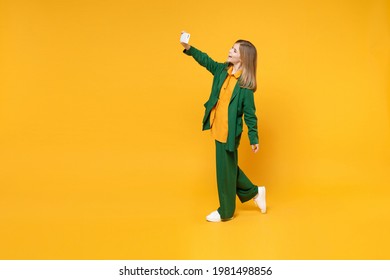 Full length side profile view of little blonde smiling kid girl 12-13 years old in casual clothes doing selfie shot on mobile phone isolated on yellow background children Childhood lifestyle concept - Shutterstock ID 1981498856