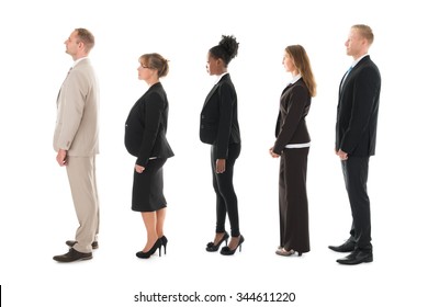 Full Length Side View Of Business Team Standing In Row Against White Background