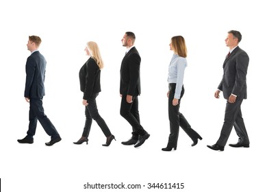 Full Length Side View Of Business People Walking Against White Background