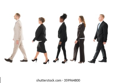 Full Length Side View Of Business Team Walking In Row Against White Background