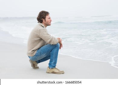 Full length side view of a casual young man relaxing at the beach - Powered by Shutterstock