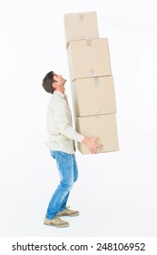 Full length side view of courier man balancing cardboard boxes on while background