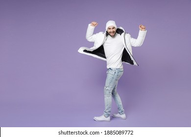 Full Length Side View Of Funny Man In White Padded Windbreaker Jacket Hat Turn Around Spreading Rising Hands Dancing Isolated On Purple Background Studio. People Lifestyle Cold Winter Season Concept