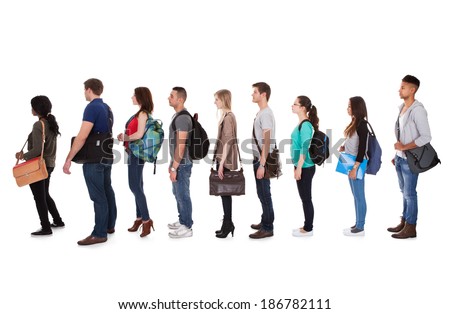 Full length side view of multiethnic college students standing in a row against white background