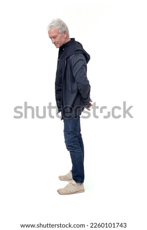 full length side view portrait of a man standing and looking down at the ground on white background