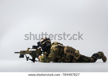 Full length side view serene peacemaker looking at sniper scope of assault rifle while locating at ground. Army concept. Copy space