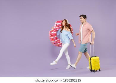 Full length side view two traveler tourist woman man couple in shirt suitcase inflatable donut ring go isolated on purple background Passenger travel abroad weekend getaway Air flight journey concept - Powered by Shutterstock