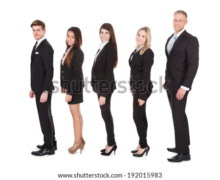 Full length side view of welldressed businesspeople standing in a line over white background