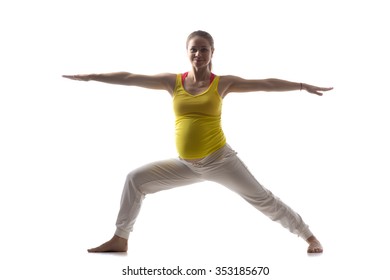 Full Length Silhouette Of Happy Young Pregnant Fitness Model In Sportswear Doing Yoga, Pilates Training, Warrior II Posture, Virabhadrasana 2, White Background, Studio, Isolated