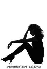 Full Length Silhouette In Shadow Of A Young Woman Sitting Sad Pensive In Studio On White Background Isolated