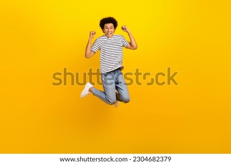 Full length size photo cadre of youngster guy jumping fists up celebrate his first job approved offer isolated on yellow color background
