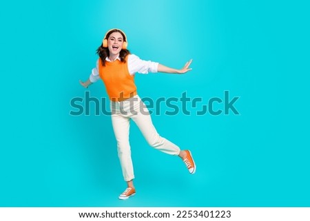Full length size photo of overjoyed careless schoolgirl listen soundtrack loud music headphones dance crazy isolated on aquamarine color background