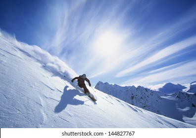 Full length of skier skiing on fresh powder snow - Shutterstock ID 144827767
