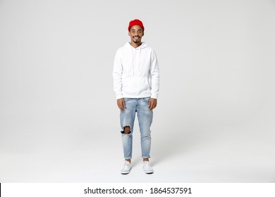Full length of smiling cheerful handsome young african american man 20s years old in casual streetwear hoodie standing and looking camera isolated on white colour wall background, studio portrait