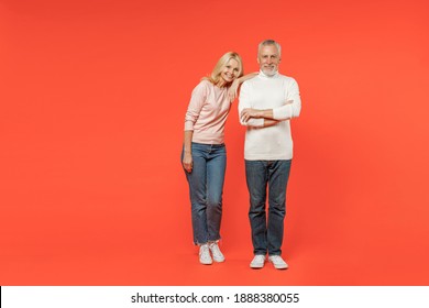 Full Length Of Smiling Couple Two Friends Elderly Gray-haired Man Blonde Woman Wearing White Pink Casual Clothes Standing Looking Camera Isolated On Bright Orange Color Background Studio Portrait