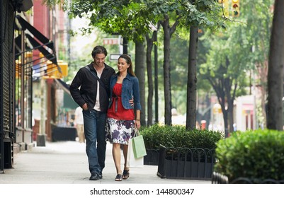 Full length of a smiling couple walking on sidewalk - Powered by Shutterstock