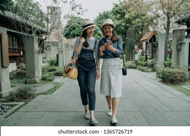 Full Length Of Smiling Happy Young Girl Friends Travelers Walking In Old Street Path Surrounding By Japanese Local Traditional Shop Store. Asian Women Searching Online Direction On Map By Smartphone