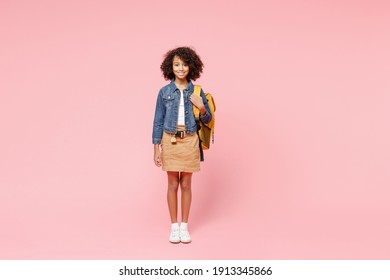 Full Length Smiling Little African American Kid School Girl 12-13 Year Old In Casual Denim Clothes With Backpack Stand Isolated On Pastel Pink Background Studio Portrait. Childhood Education Concept.