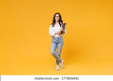 Full length of smiling young business woman in white shirt glasses isolated on yellow background studio. Achievement career wealth business concept. Mock up copy space. Hold clipboard papers document