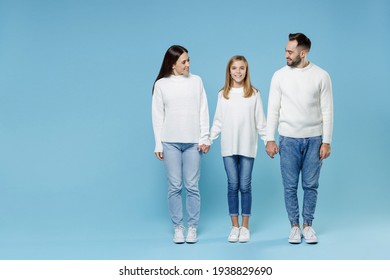 Full Length Of Smiling Young Happy Parents Mom Dad With Child Kid Daughter Teen Girl In Casual White Sweaters Holding Hands Isolated On Blue Background Studio Portrait. Family Day Parenthood Concept